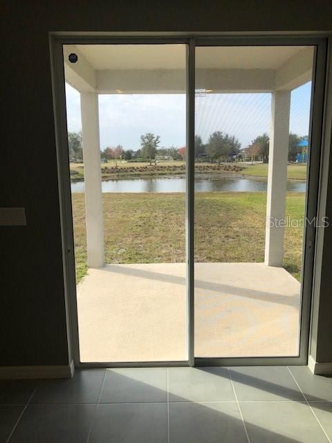 doorway to outside featuring a water view and tile patterned floors