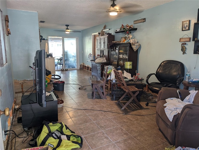 tiled living room featuring ceiling fan and a textured ceiling