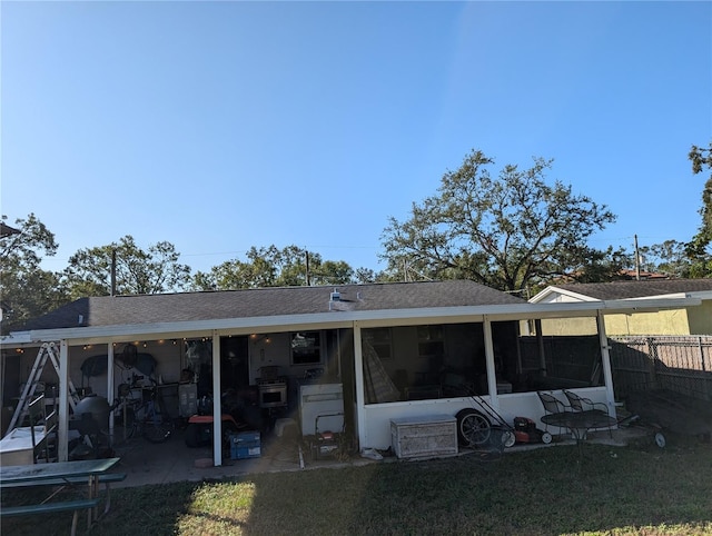 rear view of property with a sunroom, a yard, and a patio