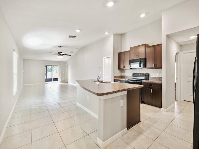 kitchen featuring black microwave, light tile patterned floors, range with electric stovetop, visible vents, and vaulted ceiling