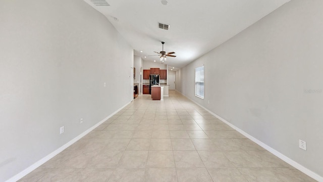 interior space featuring light tile patterned floors, baseboards, visible vents, and vaulted ceiling