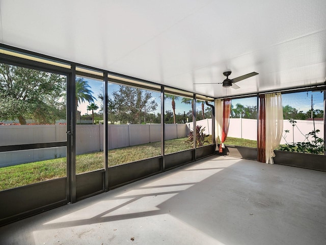 unfurnished sunroom with ceiling fan