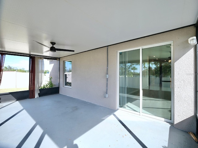 unfurnished sunroom featuring ceiling fan