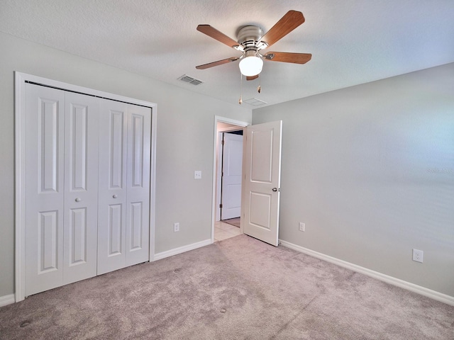 unfurnished bedroom featuring carpet, a closet, a ceiling fan, a textured ceiling, and baseboards