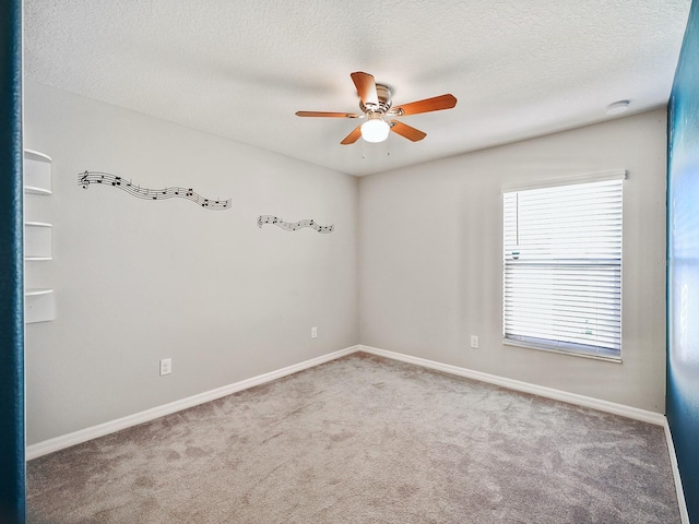 carpeted spare room featuring ceiling fan, baseboards, and a textured ceiling