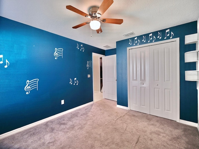 unfurnished bedroom with carpet floors, a closet, visible vents, and baseboards