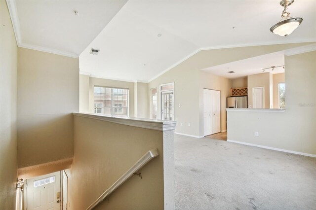 interior space with carpet, crown molding, and vaulted ceiling