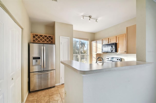 kitchen with kitchen peninsula, stainless steel refrigerator with ice dispenser, sink, light brown cabinets, and range