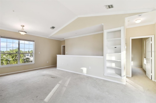 empty room with light colored carpet, ornamental molding, and vaulted ceiling