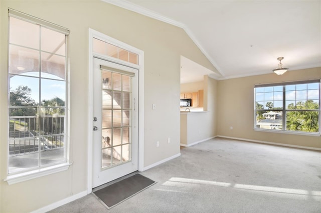 entryway with light colored carpet, vaulted ceiling, and plenty of natural light