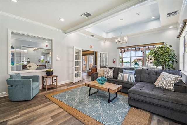 living room with a chandelier, wood-type flooring, ornamental molding, and french doors