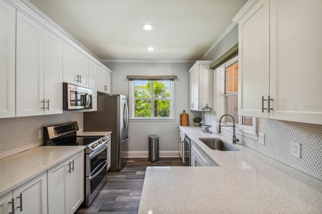 kitchen featuring white cabinets, stainless steel appliances, light stone countertops, and sink