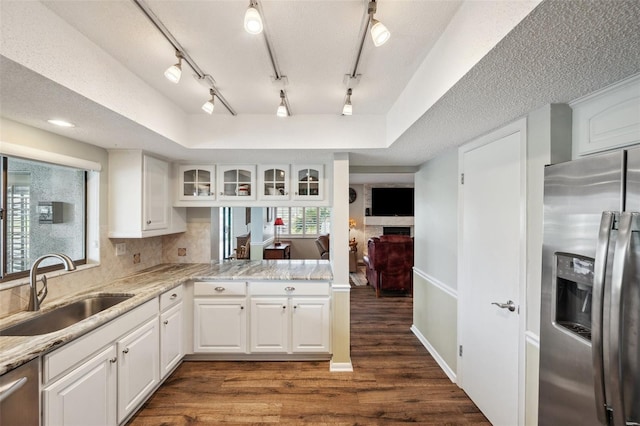 kitchen featuring dark wood-style flooring, stainless steel appliances, glass insert cabinets, white cabinetry, and a sink