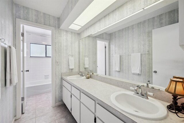 full bathroom with tile patterned floors, double vanity, a sink, and wallpapered walls