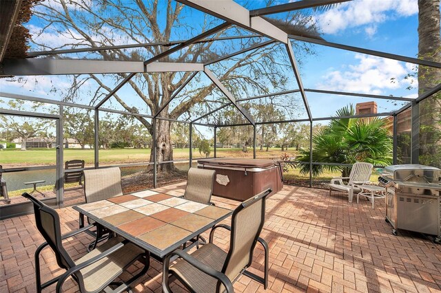 view of patio / terrace with outdoor dining area, glass enclosure, a hot tub, and area for grilling