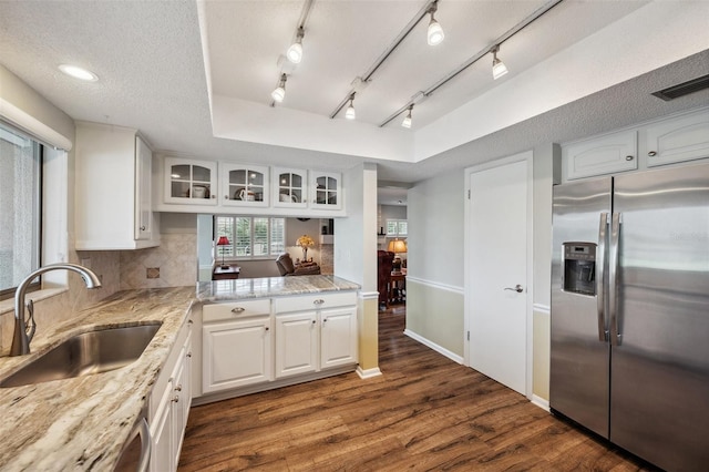 kitchen with a sink, white cabinetry, stainless steel fridge with ice dispenser, dark wood finished floors, and glass insert cabinets