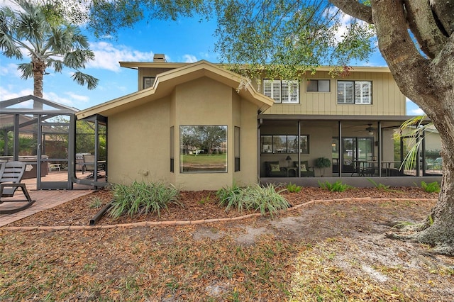 rear view of property with a lanai, a patio area, and stucco siding