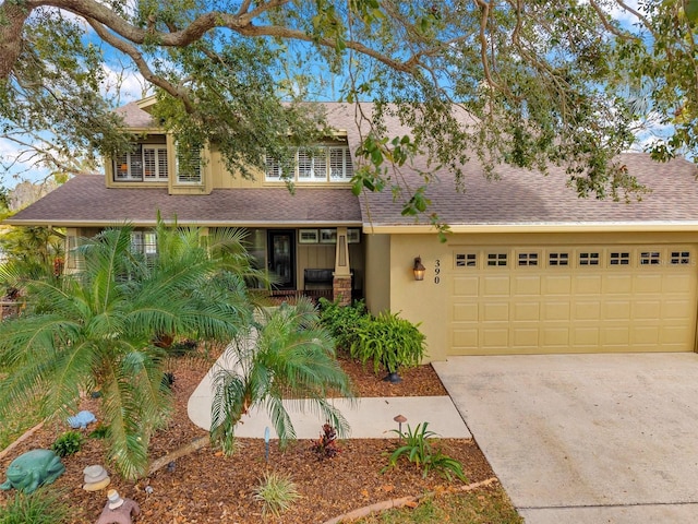 view of front of house featuring an attached garage, stucco siding, concrete driveway, and roof with shingles