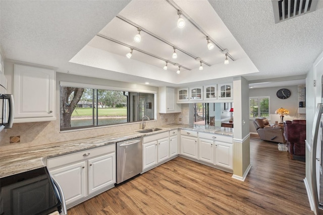 kitchen with visible vents, a tray ceiling, white cabinetry, and dishwasher