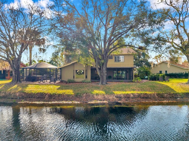 back of house featuring a water view, a yard, and a gazebo