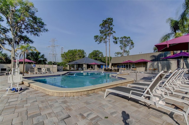 community pool with a patio and fence