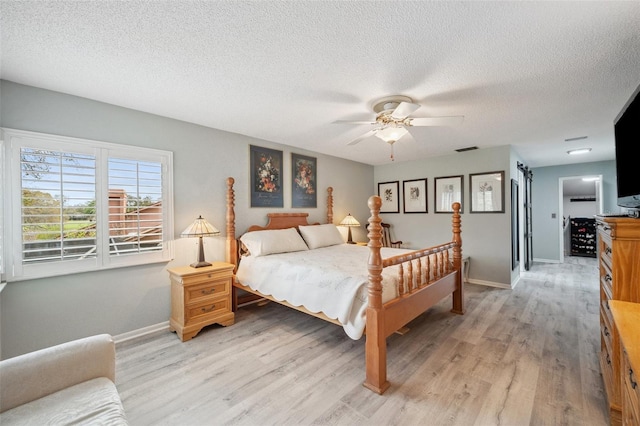 bedroom featuring light wood-style flooring, visible vents, and baseboards