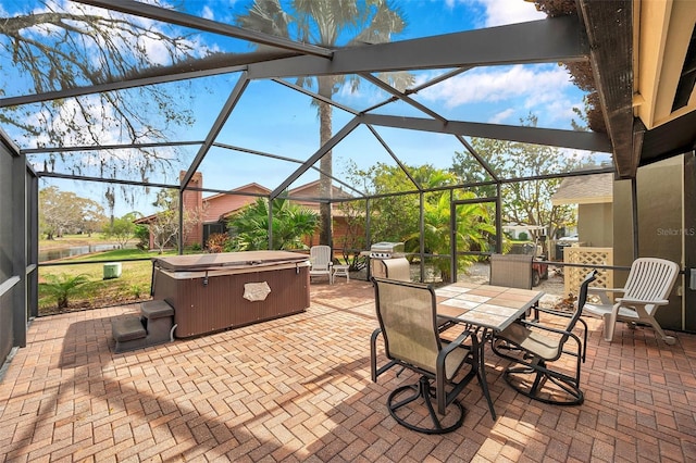 view of patio / terrace with glass enclosure and a hot tub