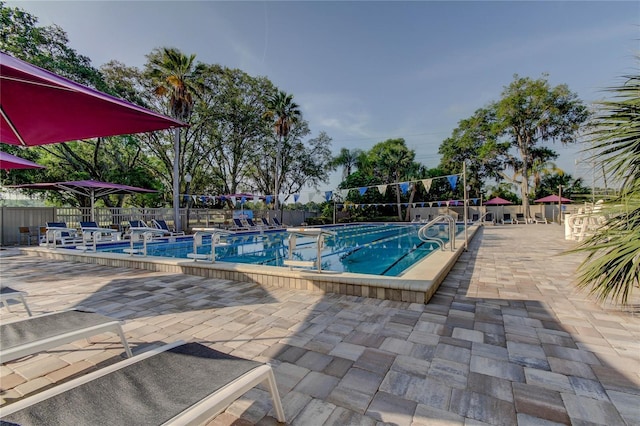 pool with a patio and fence