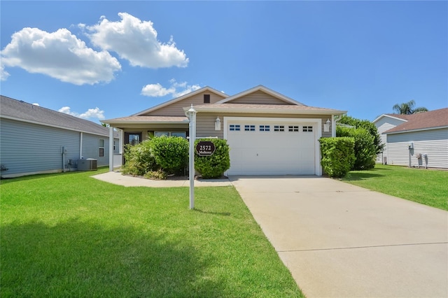 single story home with a garage, a front yard, and central AC