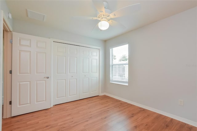 unfurnished bedroom with light wood-type flooring, ceiling fan, and a closet