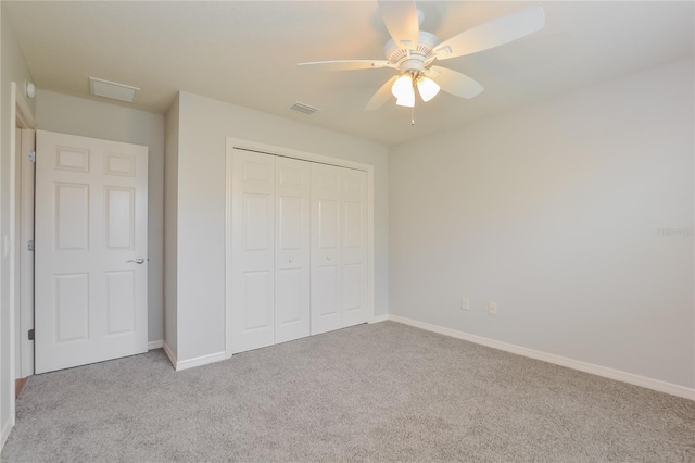 unfurnished bedroom featuring a closet, light colored carpet, and ceiling fan