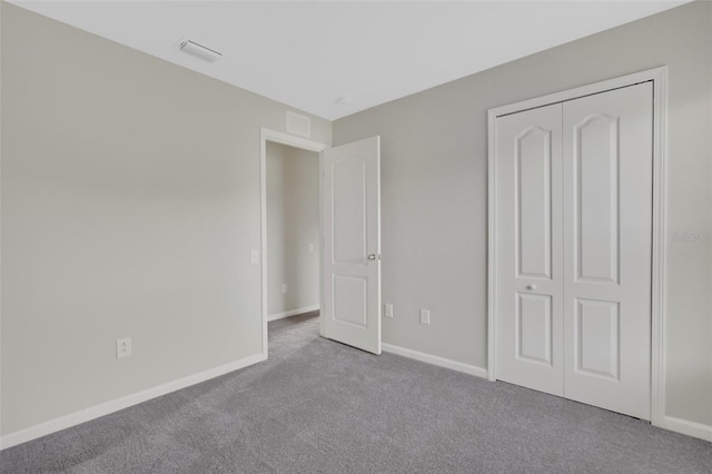 unfurnished bedroom with light carpet and a closet