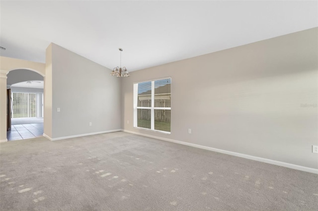 unfurnished room with light colored carpet and a notable chandelier