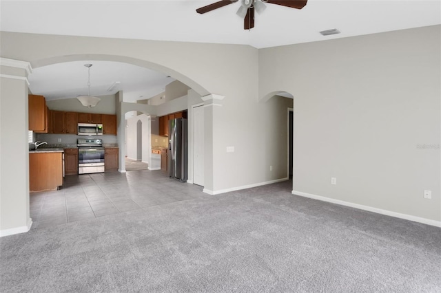 unfurnished living room with high vaulted ceiling, sink, ceiling fan, light tile patterned flooring, and decorative columns