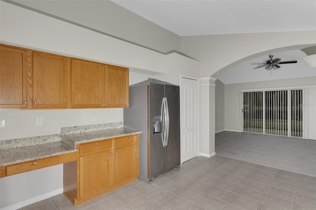 kitchen with ceiling fan, light stone counters, stainless steel fridge with ice dispenser, lofted ceiling, and light carpet