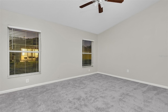 carpeted spare room featuring ceiling fan and vaulted ceiling