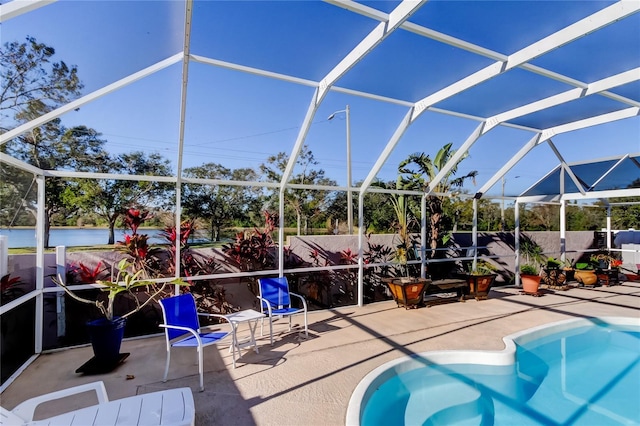 view of swimming pool with a lanai, a patio, and a water view