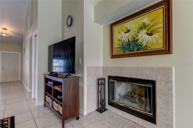 living room featuring a tiled fireplace and light tile patterned floors