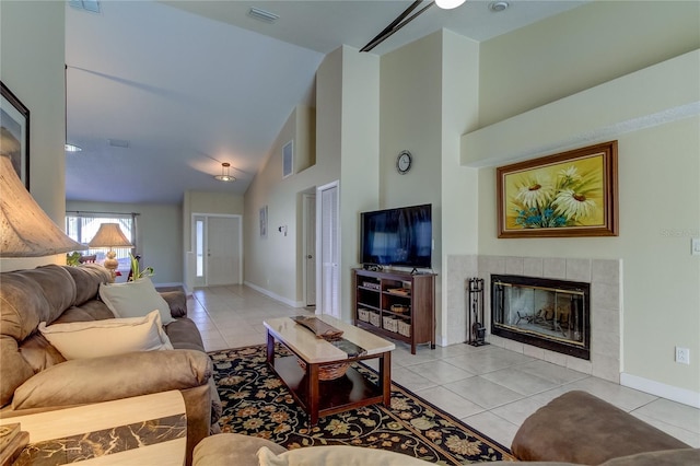 living room featuring a tiled fireplace, high vaulted ceiling, and light tile patterned floors