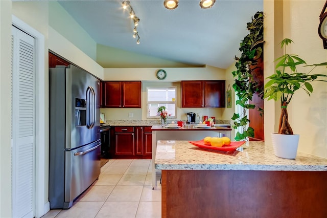 kitchen featuring stainless steel fridge with ice dispenser, vaulted ceiling, light stone countertops, and light tile patterned flooring