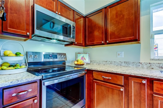 kitchen featuring stainless steel appliances and light stone countertops