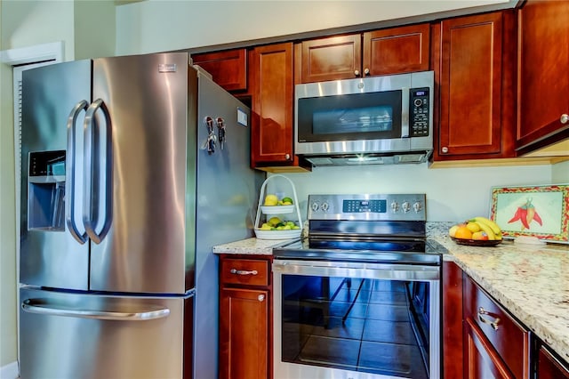 kitchen featuring light stone counters and stainless steel appliances