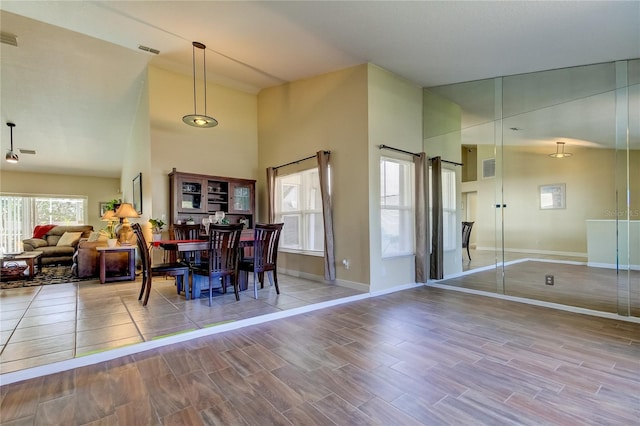 dining space featuring a high ceiling and light hardwood / wood-style flooring