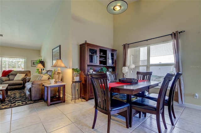 tiled dining room featuring plenty of natural light and high vaulted ceiling