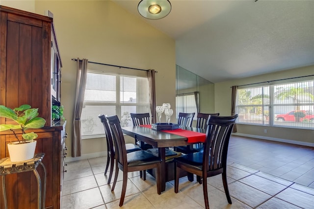 tiled dining space featuring high vaulted ceiling