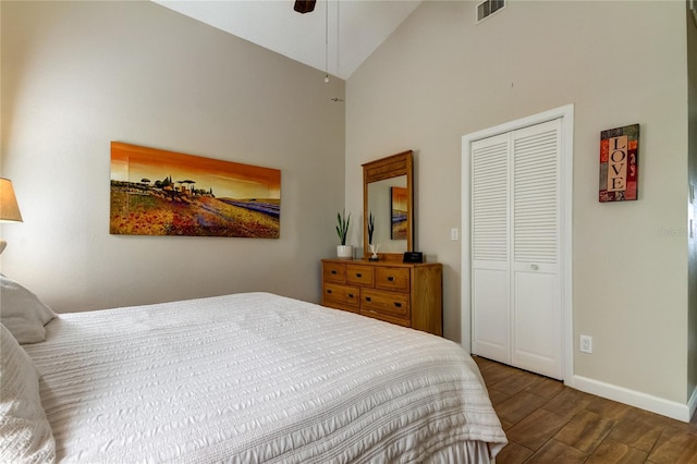 bedroom with dark hardwood / wood-style flooring, high vaulted ceiling, a closet, and ceiling fan