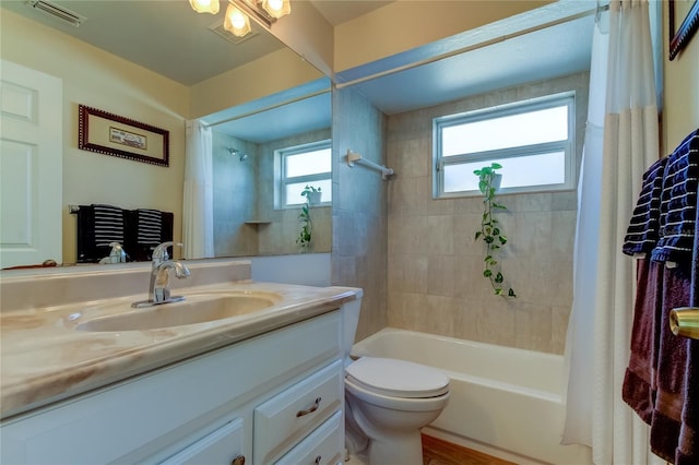 full bathroom with shower / bathtub combination with curtain, vanity, and toilet