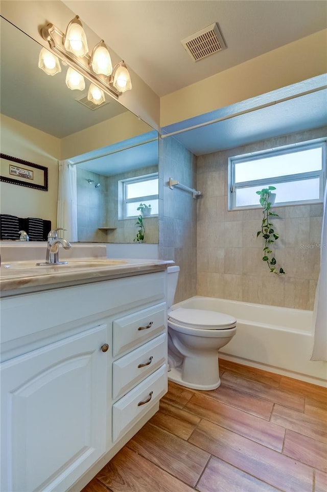 full bathroom featuring vanity, a wealth of natural light, shower / tub combo with curtain, and toilet