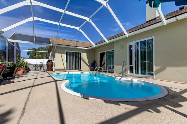 rear view of property featuring a patio and glass enclosure