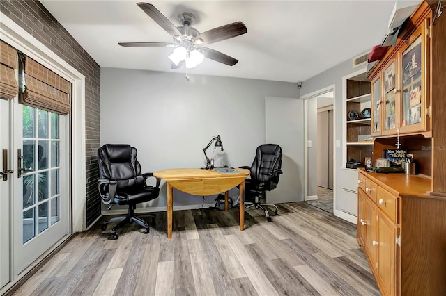 office area featuring ceiling fan, light hardwood / wood-style floors, and brick wall